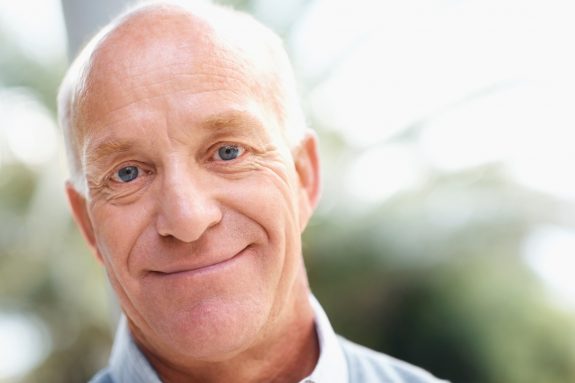 Closeup portrait of a confident old senior man smiling